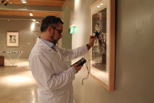 el curador Mario Montañez, realizando control de luz sobre las obras