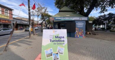 Mapa turístico de Quilpué en mano, frente a la Oficina de Información Turística en Plaza Irarrazabal, destacando atractivos culturales y naturales.