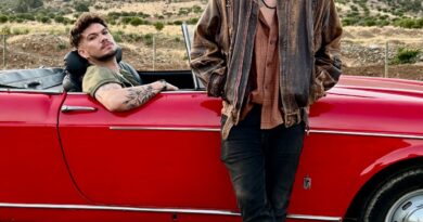 Diego y Chiris de Triciclo Parlante, estilo rock, junto a auto rojo convertible en paisaje montañoso. Álbum Re:nacer.