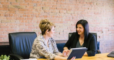 Dos profesionales revisan datos en tablet, discutiendo mercado laboral, empleo, aumento salarial o reinvención.