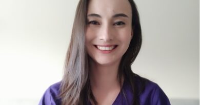 Chris Pefaur, nutricionista Nutrapharm, sonríe. Pelo oscuro, uniforme morado. Teletrabajo y salud.