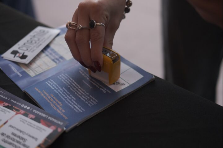 Mano sella programa oficial del 17° FECICH en Quilpué. Requisito para CLUB FECICH y concierto Ángel Parra Trío.