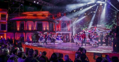 Festival del Huaso de Olmué en El Patagual. Bailarines folclóricos en escenario con casas coloniales iluminadas.