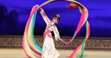 Artista de Ópera Wu de Zhejiang en Viña del Mar, con traje tradicional y cintas de colores, celebrando Año Nuevo Chino.
