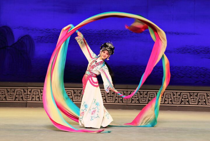 Artista de Ópera Wu de Zhejiang en Viña del Mar, con traje tradicional y cintas de colores, celebrando Año Nuevo Chino.