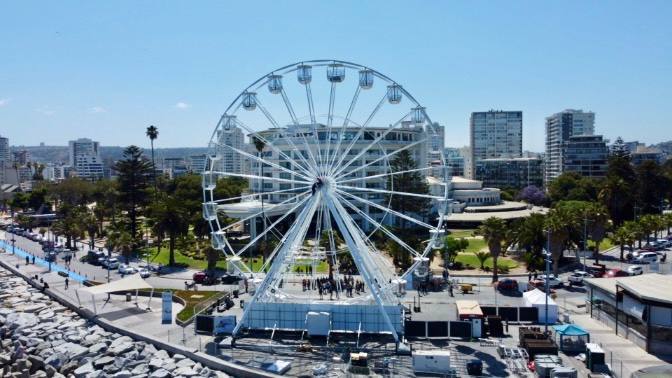 Gran Rueda en Avenida Perú, Viña del Mar. Vista de la ciudad costera con edificios y palmeras, parte de las atracciones de verano.