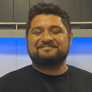 Camilo Bastías, psicólogo de Grupo Cetep, sonríe. Aborda la salud mental de cuidadores de cáncer.