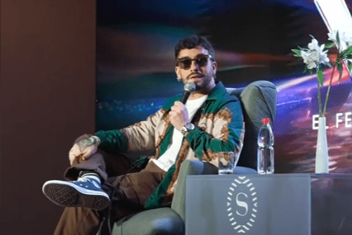 Edo Caroe con gafas y micrófono en conferencia de prensa Viña 2025 en Sheraton Miramar, previo al apagón.