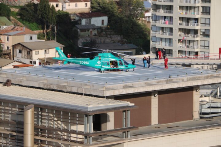 Helicóptero Rescate Alemana CC-DBA en helipuerto del Hospital Fricke con equipo médico. Crucial para traslados vitales.