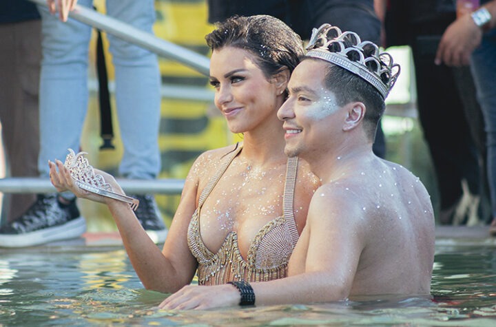 Emilia Dides y Camilo González, Reyes de Viña, sonríen en el piscinazo del Novotel, con coronas y brillos.