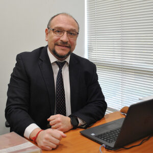 Dr. Pedro Mayorga Cordero, autor de 'Persona humana: Piedra angular de la libertad', sonríe en su oficina.