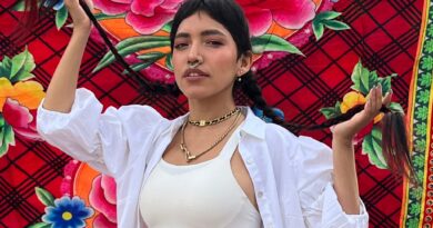 Renata Flores, Reina del Rap Quechua de Perú, con trenzas y joyas, frente a textil andino floral. Viña 2025.