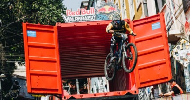 Ciclista de descenso urbano Red Bull Valparaíso Cerro Abajo saltando un contenedor rojo. Acción extrema en Valparaíso.