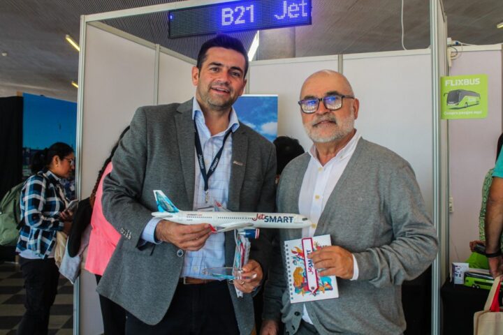 Hombres en FITVAL 2025 con maqueta JetSMART. Explora ofertas de vuelos y turismo en Valparaíso Región.