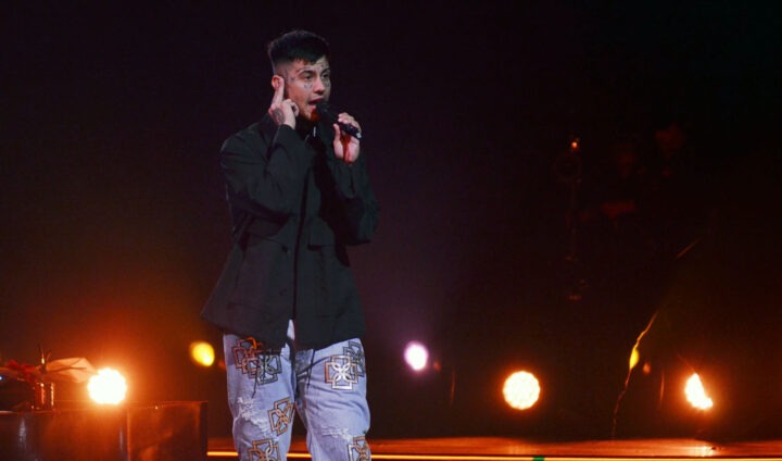 Duki, rey del trap argentino, en vivo en Viña 2025. Canta con micrófono, chaqueta oscura y jeans estampados.