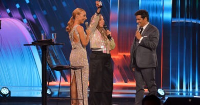 Pam Pam alza su Gaviota de Plata en el escenario de Viña del Mar, flanqueada por los animadores del festival.