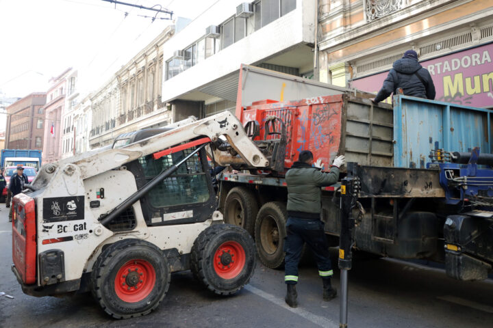 Valparaíso: Operarios municipales retiran kiosco abandonado en calle Esmeralda con Bobcat y camión.