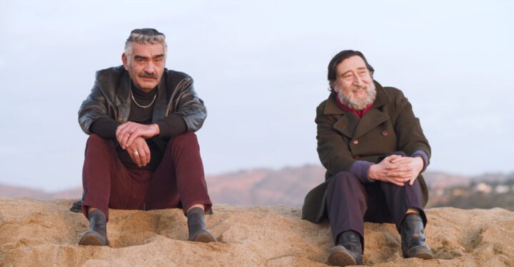 Daniel Antivilo (Ricky Palace) y José Soza, actores de "Los años salvajes", sentados en la arena. Cierre ciclo cine chileno.