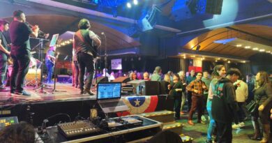 Banda en vivo y público bailando en la Gran Fonda Enjoy Viña del Mar. Bandera chilena y equipo DJ en escenario.