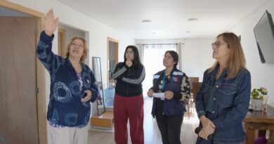 Cuatro mujeres en un hogar moderno y luminoso. Una señala al techo, las otras tres observan con atención.