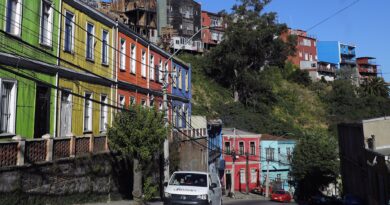 Valparaíso: Calle Carampangue con casas coloridas en cerro. Vía con baches y grietas, previo a su proyecto de mejoramiento vial.