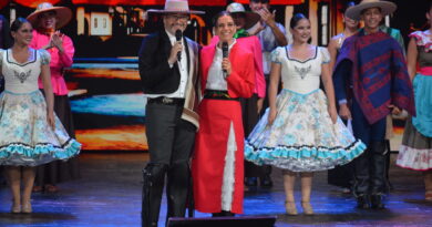 Presentadores y bailarines chilenos en trajes típicos de huaso y cueca sobre un escenario vibrante de festival.
