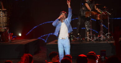 Cantante de cuarteto argentino enérgico en Festival Olmué 2026. Luce atuendo azul brillante, escenario y público vibrante.