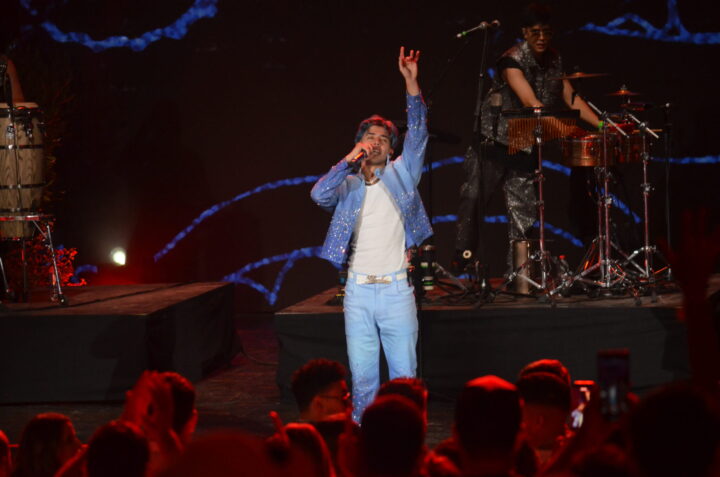 Cantante de cuarteto argentino Luck Ra, enérgico en Festival del Huaso de Olmué 2026. Luce atuendo azul brillante, escenario y público vibrante.
