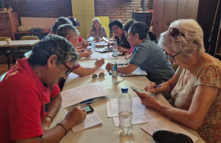 Adultos mayores aprendiendo a usar smartphones en un taller de tecnología. Reducir brecha digital, autonomía.