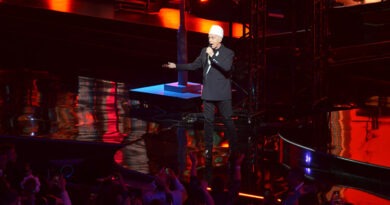 Neil Tennant (Pet Shop Boys) actuando en Viña del Mar 2026. Escenario oscuro con luces rojas y azules.