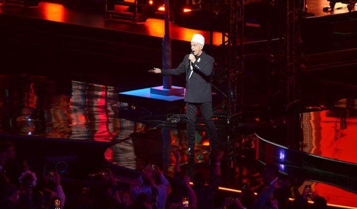 Neil Tennant (Pet Shop Boys) actuando en Viña del Mar 2026. Escenario oscuro con luces rojas y azules.