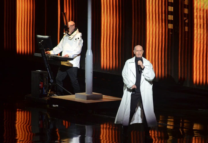 Pet Shop Boys en concierto Viña del Mar. Neil Tennant canta, Chris Lowe toca teclado. Vestuario blanco en escenario iluminado.