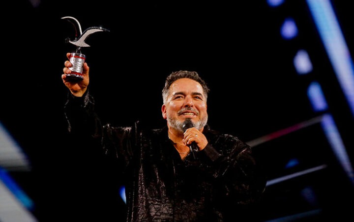 Rodrigo Villegas, comediante, levanta sonriente la Gaviota de Plata en Viña del Mar. Éxito humor chileno.