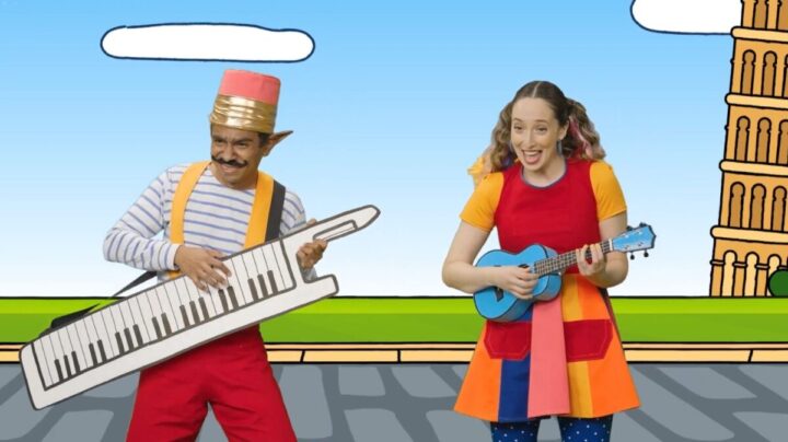 Divertidos personajes infantiles, lápiz con teclado y mujer con ukelele, en escenario animado con torre inclinada. TVN.