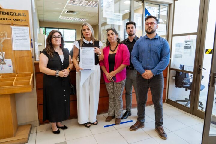 Grupo de 5 personas en oficina judicial en Quilpué, Alcaldesa muestra documento legal. Relacionado con acción judicial por fuegos artificiales con resultado de incendio.