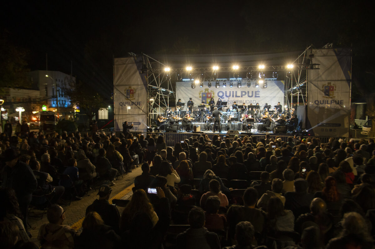 Público disfrutando de la Orquesta Municipal de Quilpué en un concierto nocturno.