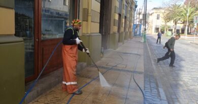 Trabajador municipal usando hidrolavadora en una calle de Valparaíso.