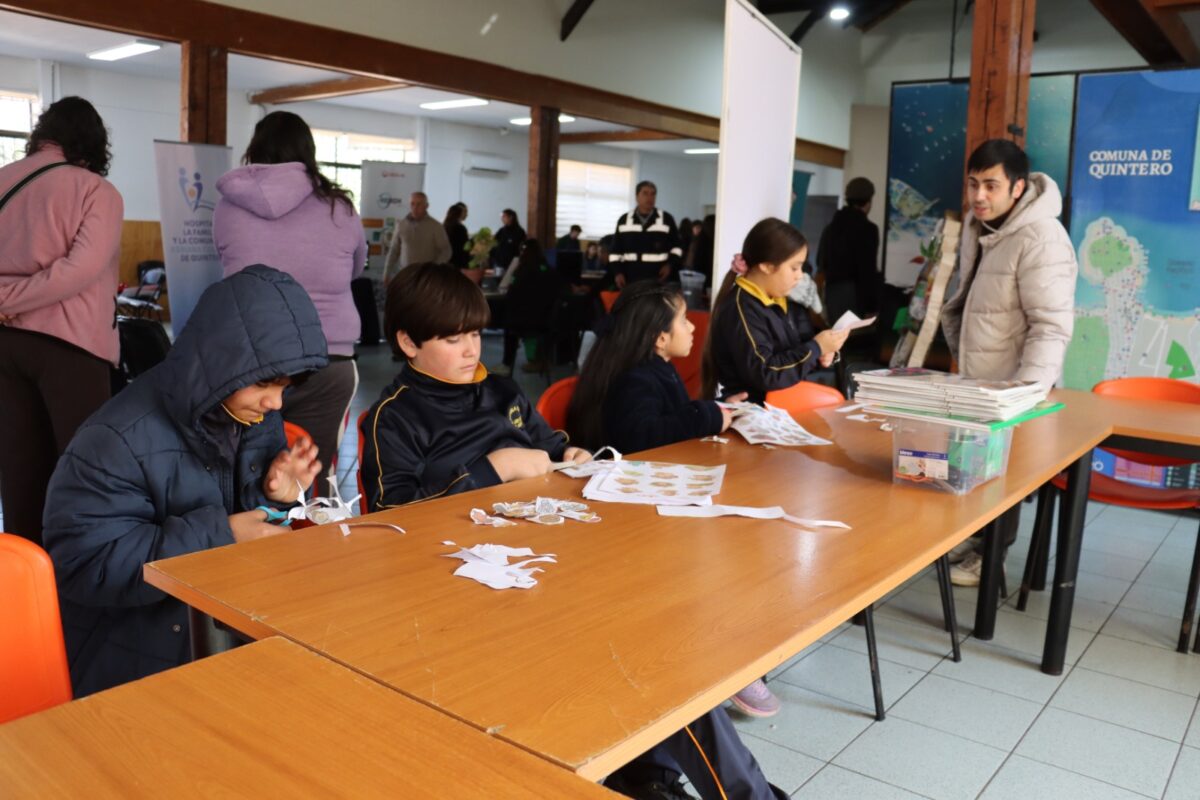 Niños participan activamente en un taller de reciclaje durante la feria de Quintero.