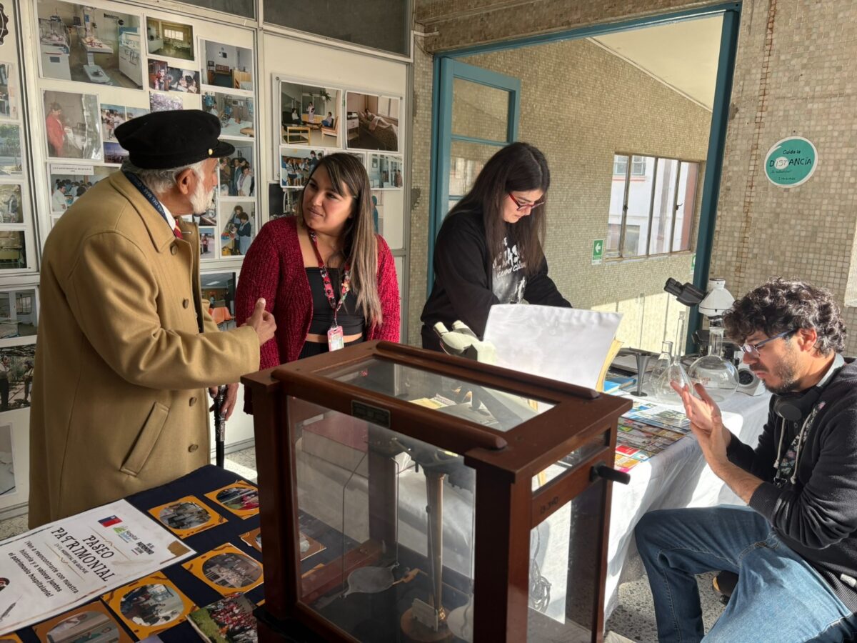 Personas conversando en el stand del Paseo Patrimonial, con elementos históricos del hospital.
