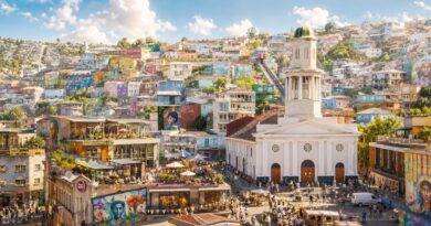 Valparaíso, con sus cerros llenos de casas coloridas y una iglesia blanca en primer plano.