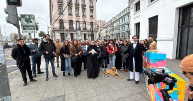 Grupo de personas en una calle de Valparaíso durante el Día del Patrimonio, con el Duoc UC de fondo.