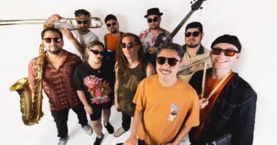 Integrantes de la banda chilena Kelu posando con sus instrumentos musicales sobre un fondo blanco.