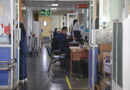 Pasillo de hospital con personal médico trabajando en sus puestos.