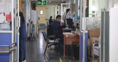 Pasillo de hospital con personal médico trabajando en sus puestos.