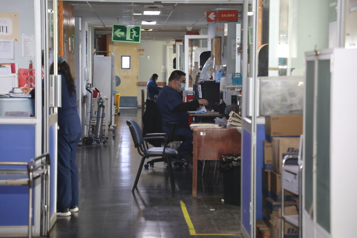 Pasillo de hospital con personal médico trabajando en sus puestos.