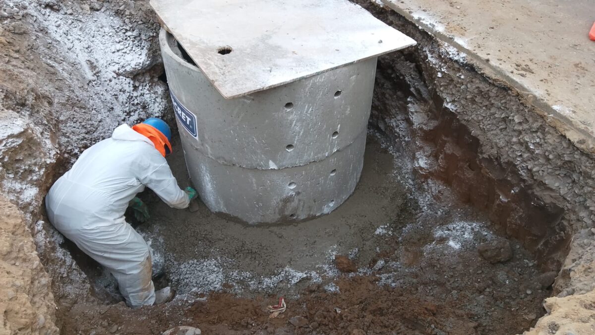 Operario de Esval trabajando en la instalación de una cámara de inspección para la red de alcantarillado.