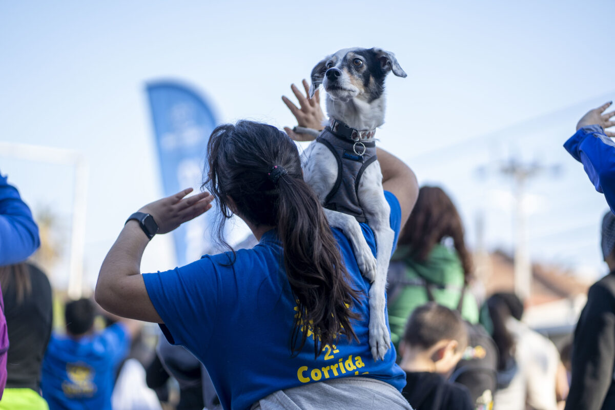 Una mujer con su perro al hombro participando en la corrida familiar de Quilpué.