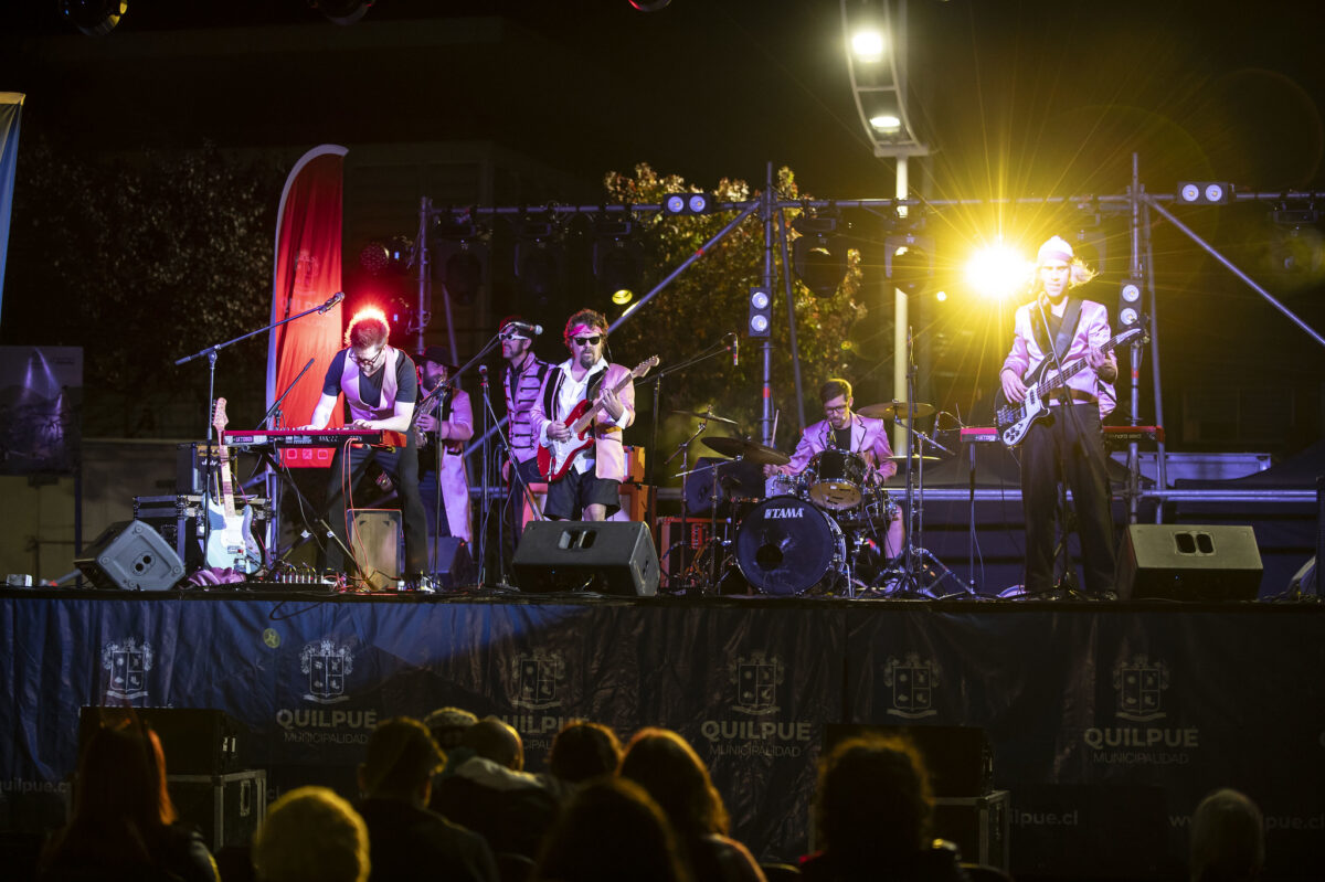Banda musical presentándose en vivo en un escenario nocturno en Quilpué.
