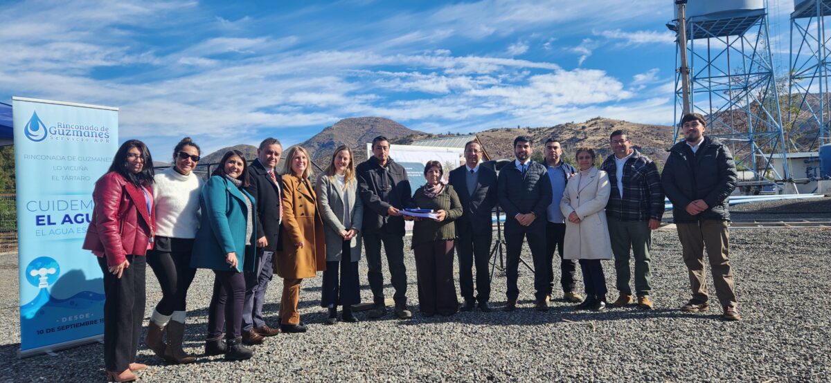 Ceremonia de primera piedra con entrega de un documento entre autoridades.