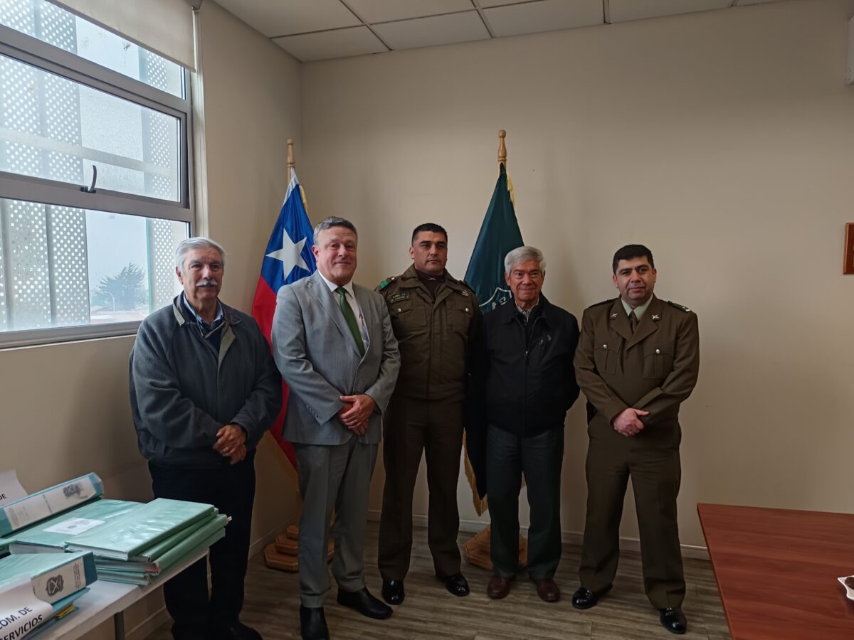 Seremi de Seguridad Pública Hernán Silva junto al cabo primero Michel Castro y acompañantes en la ceremonia de reconocimiento.